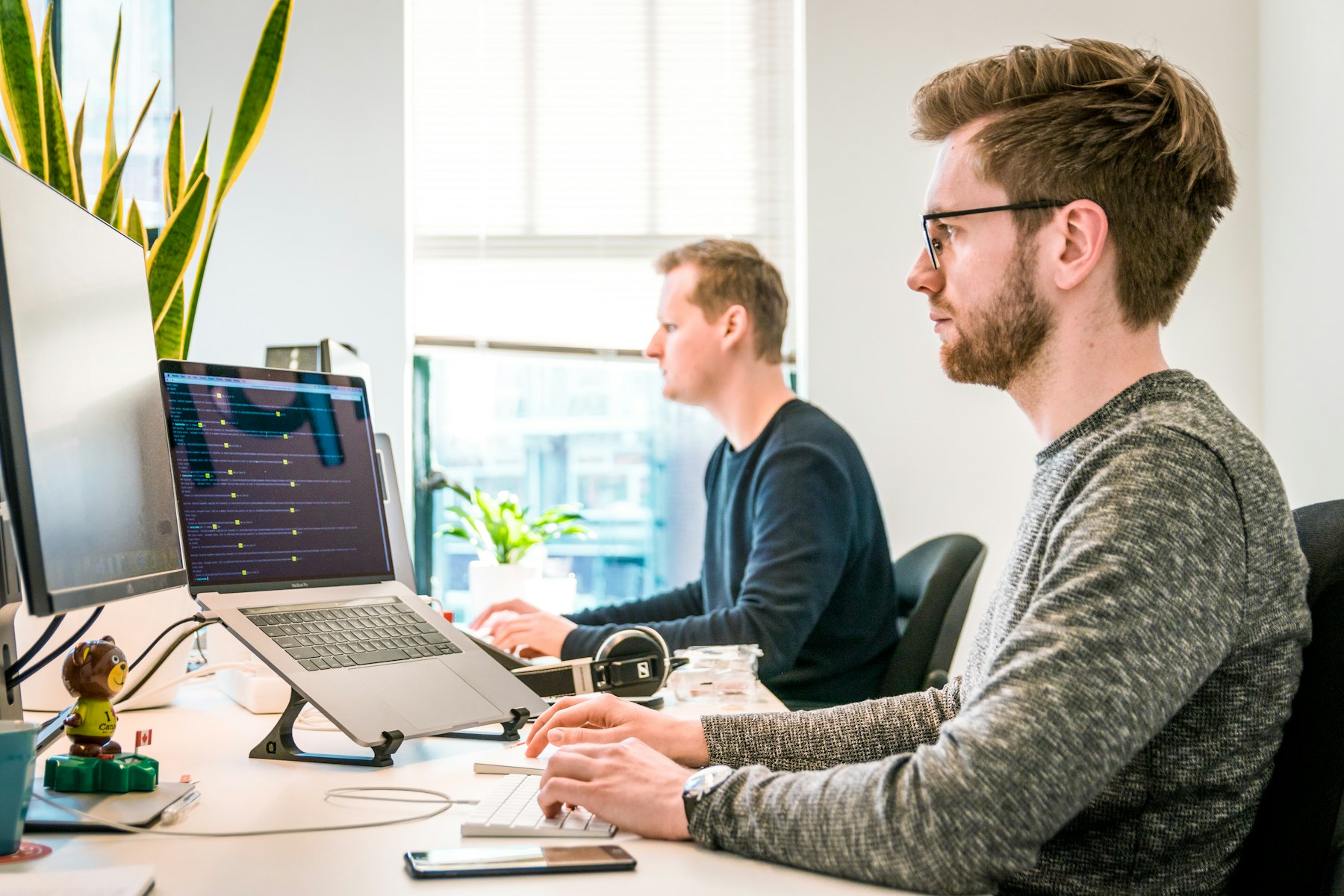 A modern office workspace with laptops and screens