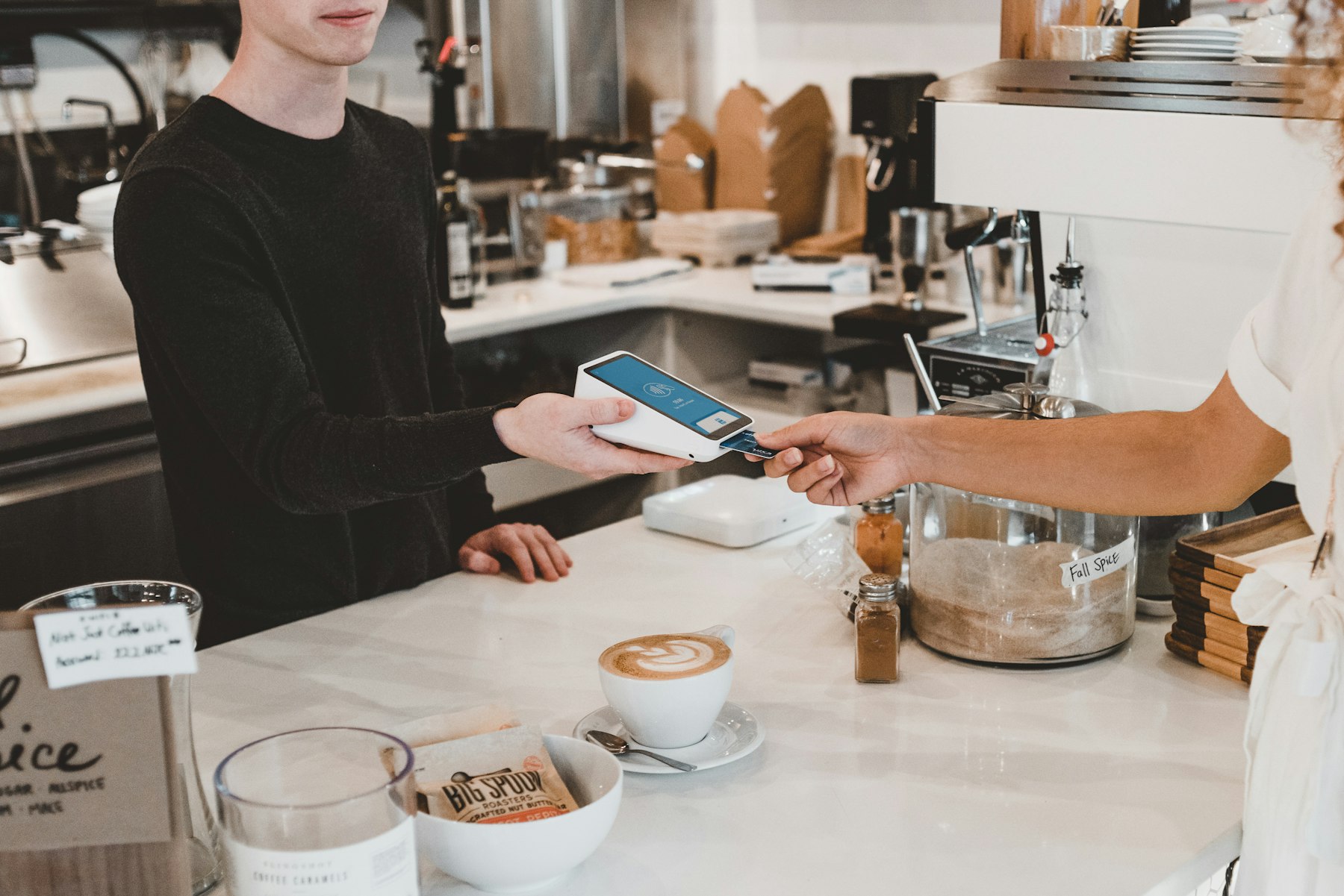 A customer paying by phone at a café counter
