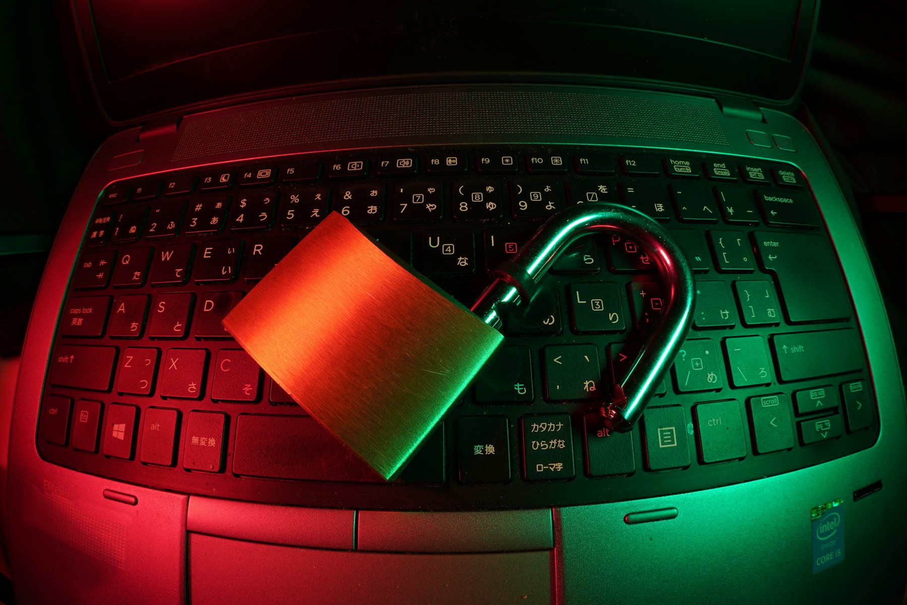 A padlock resting on a laptop keyboard lit red and green